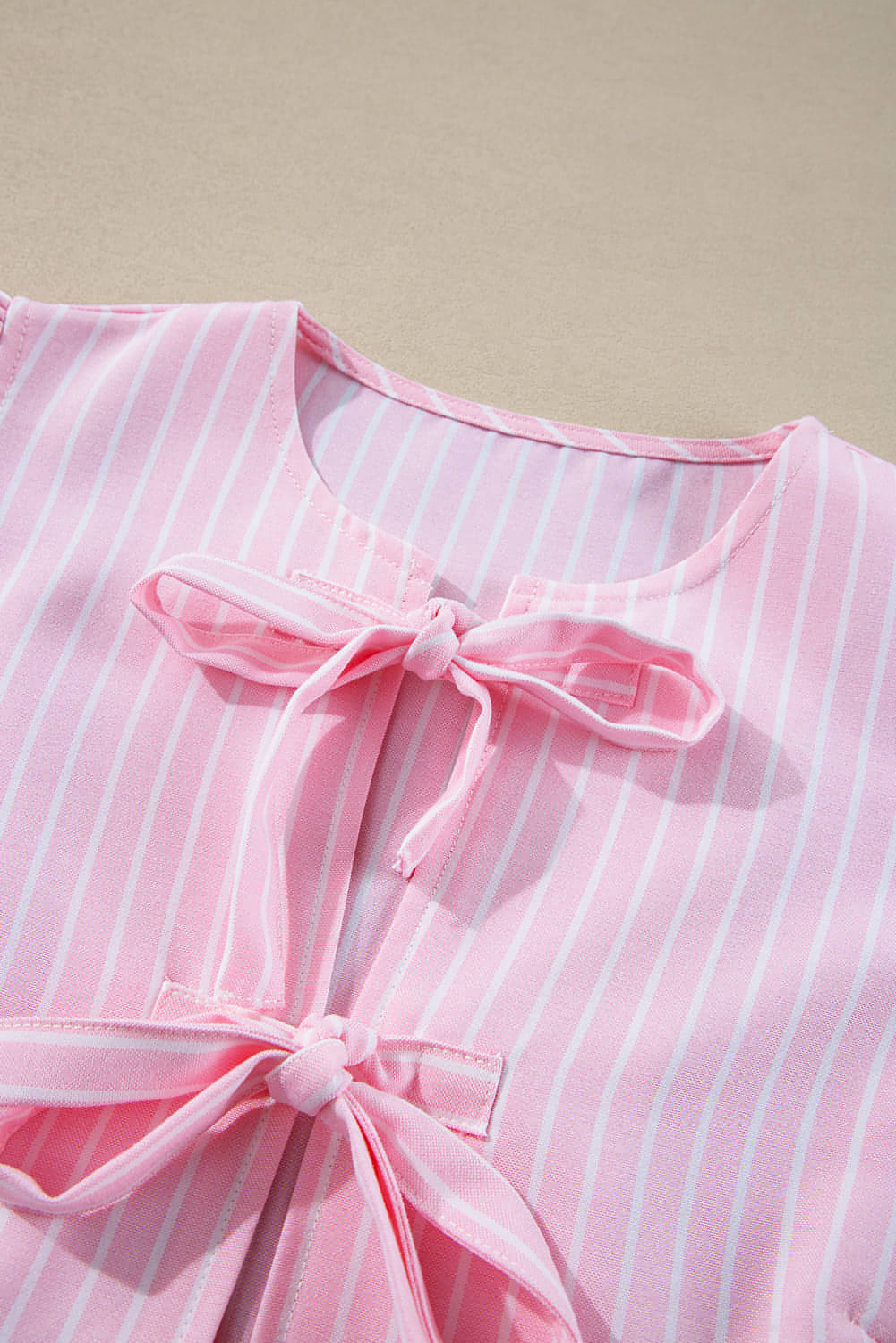 Pink stripe bowknot front crew neck puff sleeve blouse by Carmine Juneberry, featuring a stylish bowknot detail and puffed sleeves.