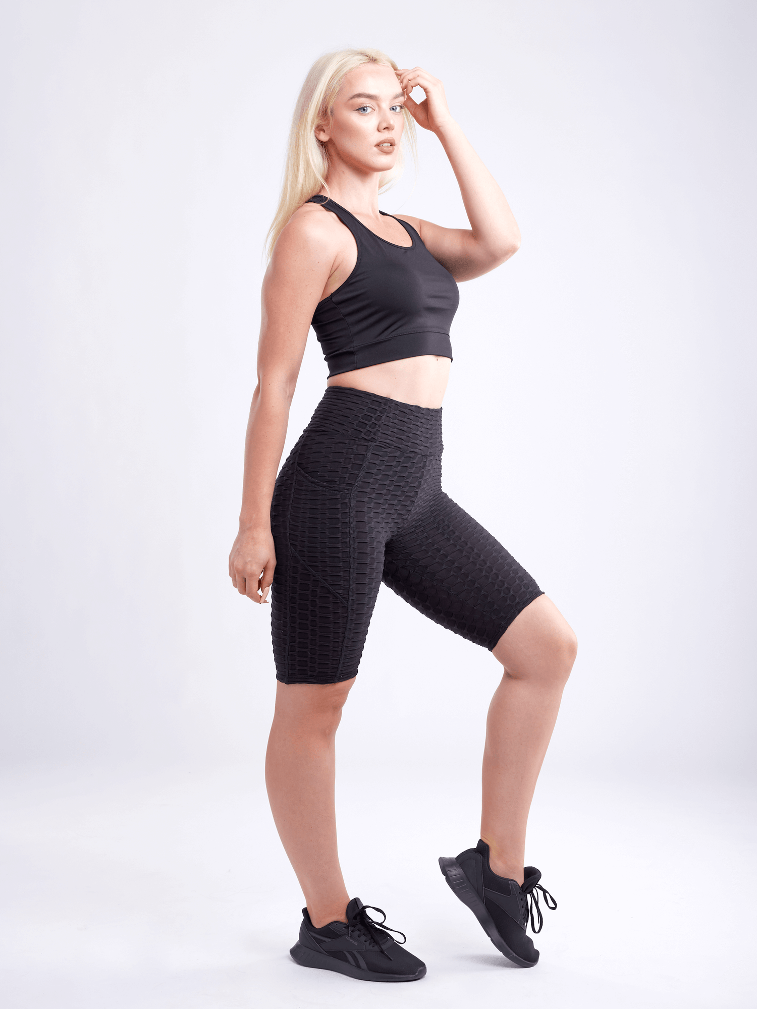 Black Lavender JupiterGear high-waisted scrunch yoga shorts with hip pockets, showcasing a close-up of the black activewear fabric and design.