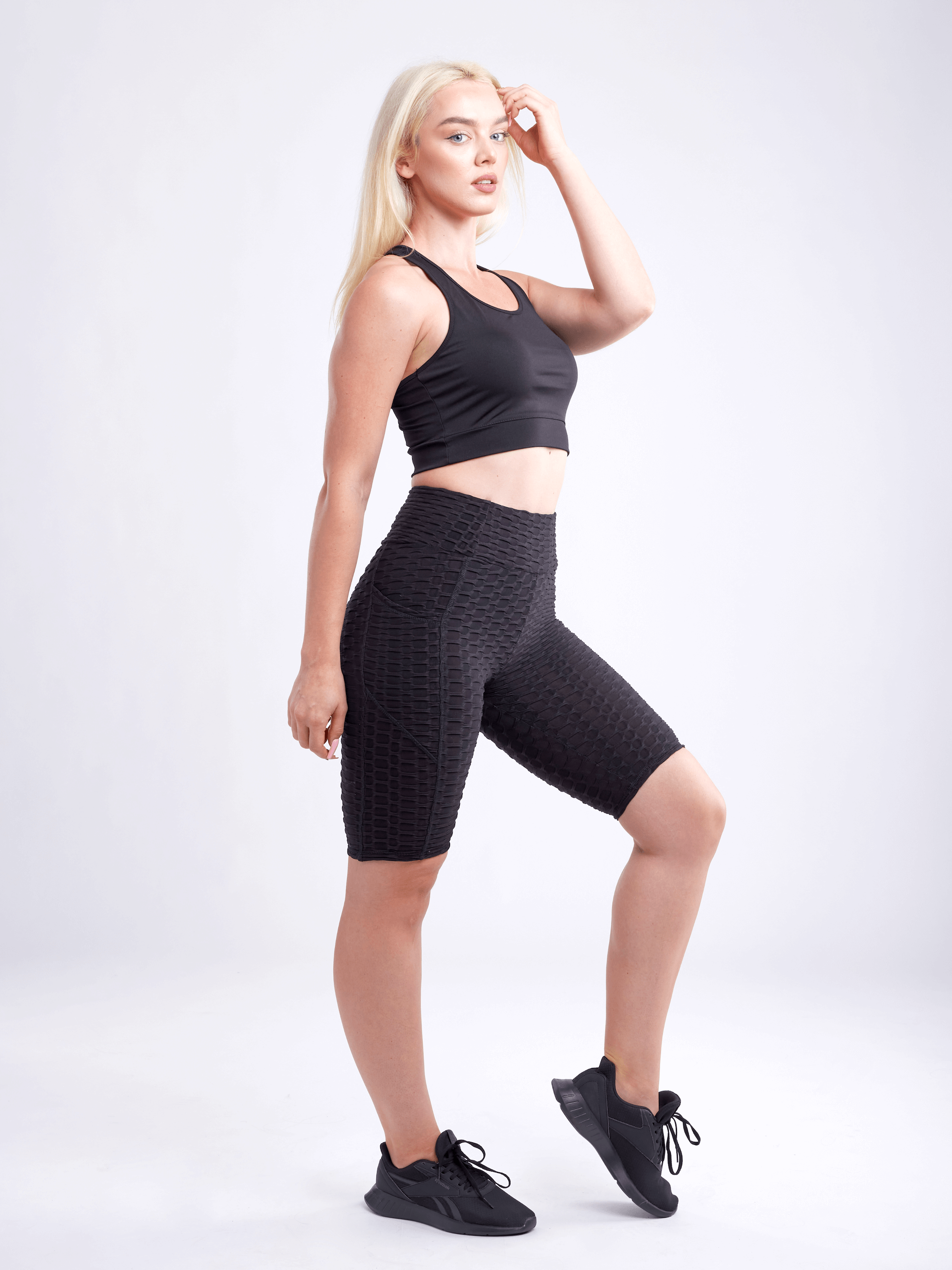 Black Lavender JupiterGear high-waisted scrunch yoga shorts with hip pockets, showcasing a close-up of the black activewear fabric and design.