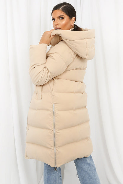 Beige hooded longline puffer coat by Rose Eleusis, featuring a quilted design and oversized fit, perfect for cold weather.