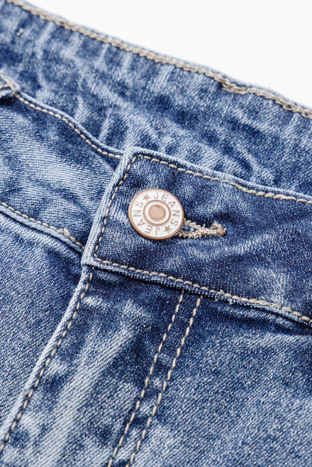 Dusk blue high-rise ripped distressed hem flared jeans by Carmine Juneberry displayed on a hanger.