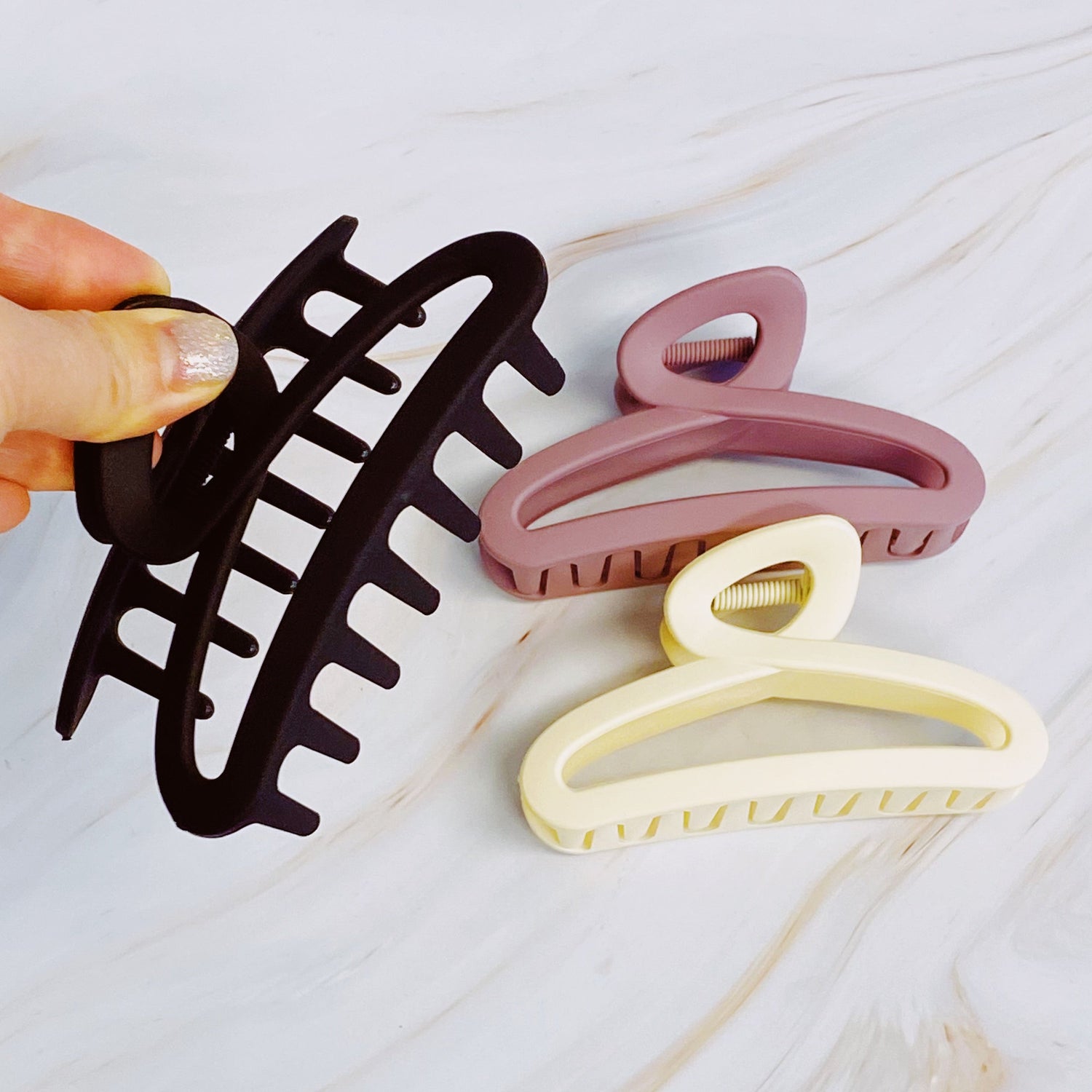 Set of three Fuchsia Hercules hair claw clips from the Hold Your Hair jewelry collection, shown in a close-up image.
