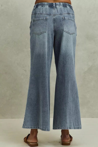 Pear Daisy SO ME mid-rise elastic waist flare denim jeans with a relaxed fit, shown on a model in a home and garden setting.