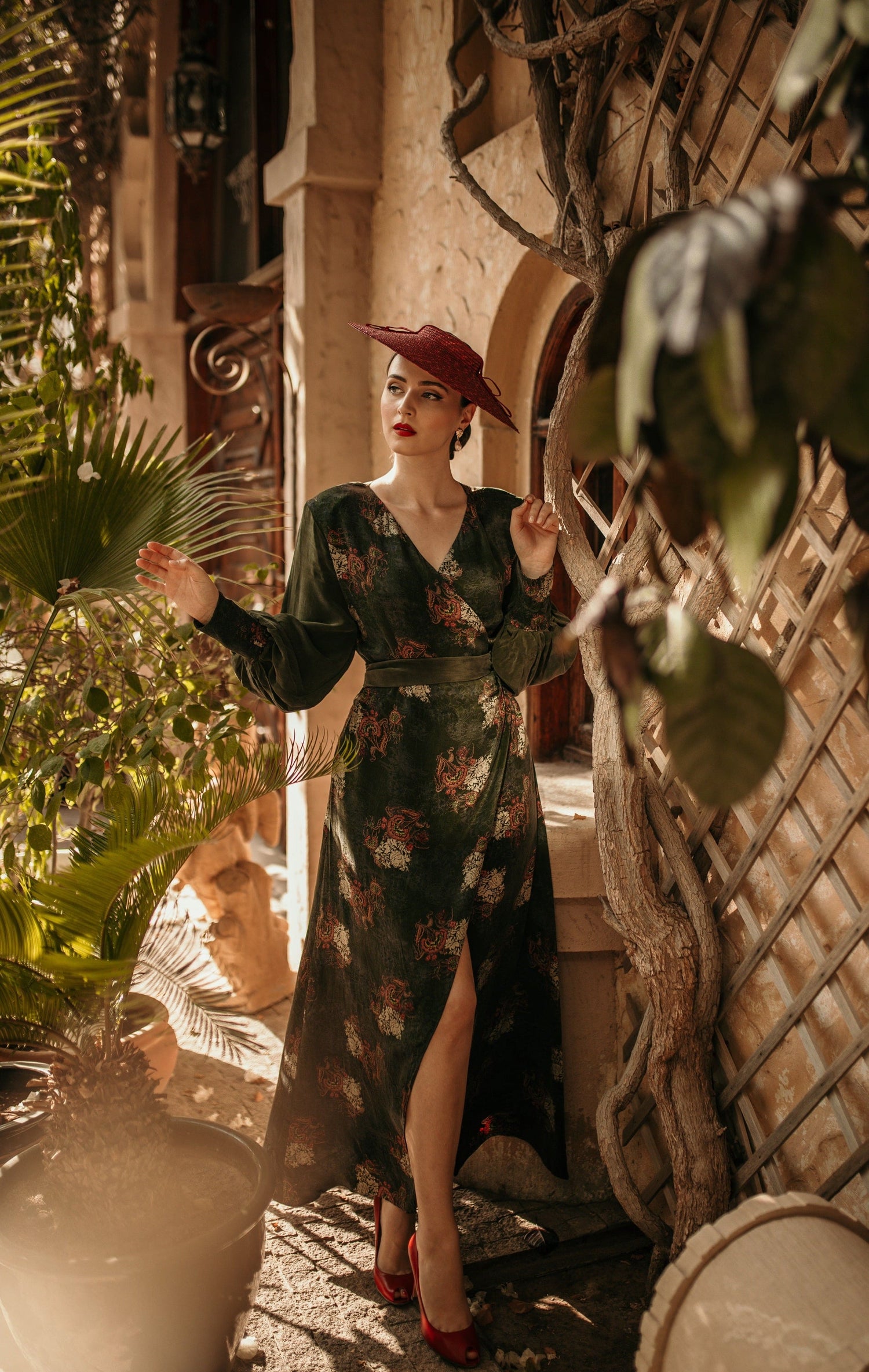 Blush Athena long sleeve wrap dress with a fitted waist and deep V neckline, shown on a model in a stylish indoor setting.