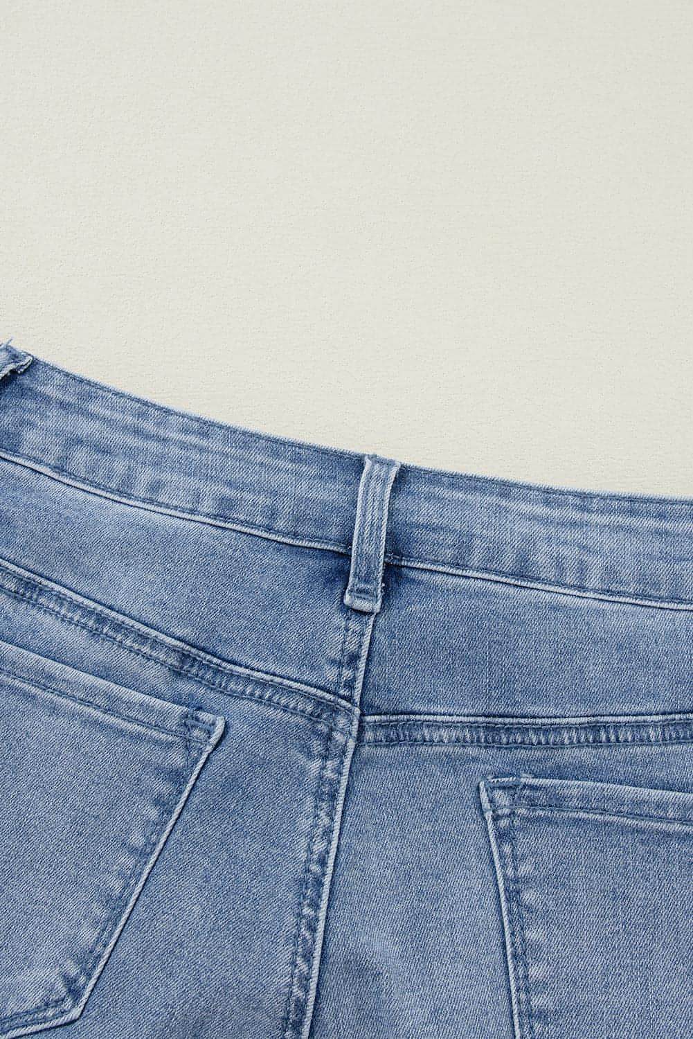Carmine Juneberry Ashleigh Blue acid wash distressed wide leg high waist jeans on a model showing the relaxed fit and distressed details.