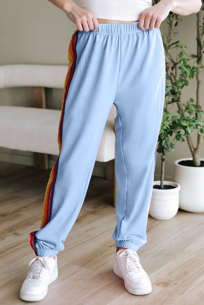 Light blue counting rainbows high waist sweatpants by Carmine Juneberry, featuring a comfortable fit and colorful rainbow pattern.