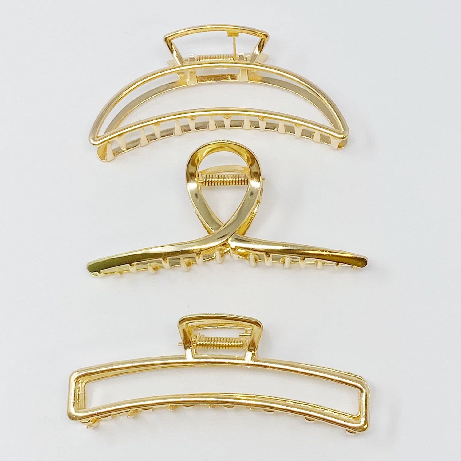 Set of three gold hair claw clips from Fuchsia Hercules, featuring sleek and elegant jewelry hair accessories.