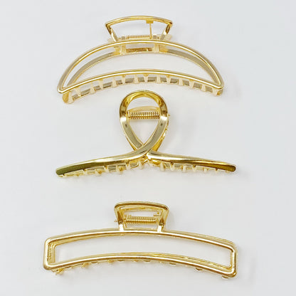 Set of three gold hair claw clips from Fuchsia Hercules, featuring sleek and elegant jewelry hair accessories.