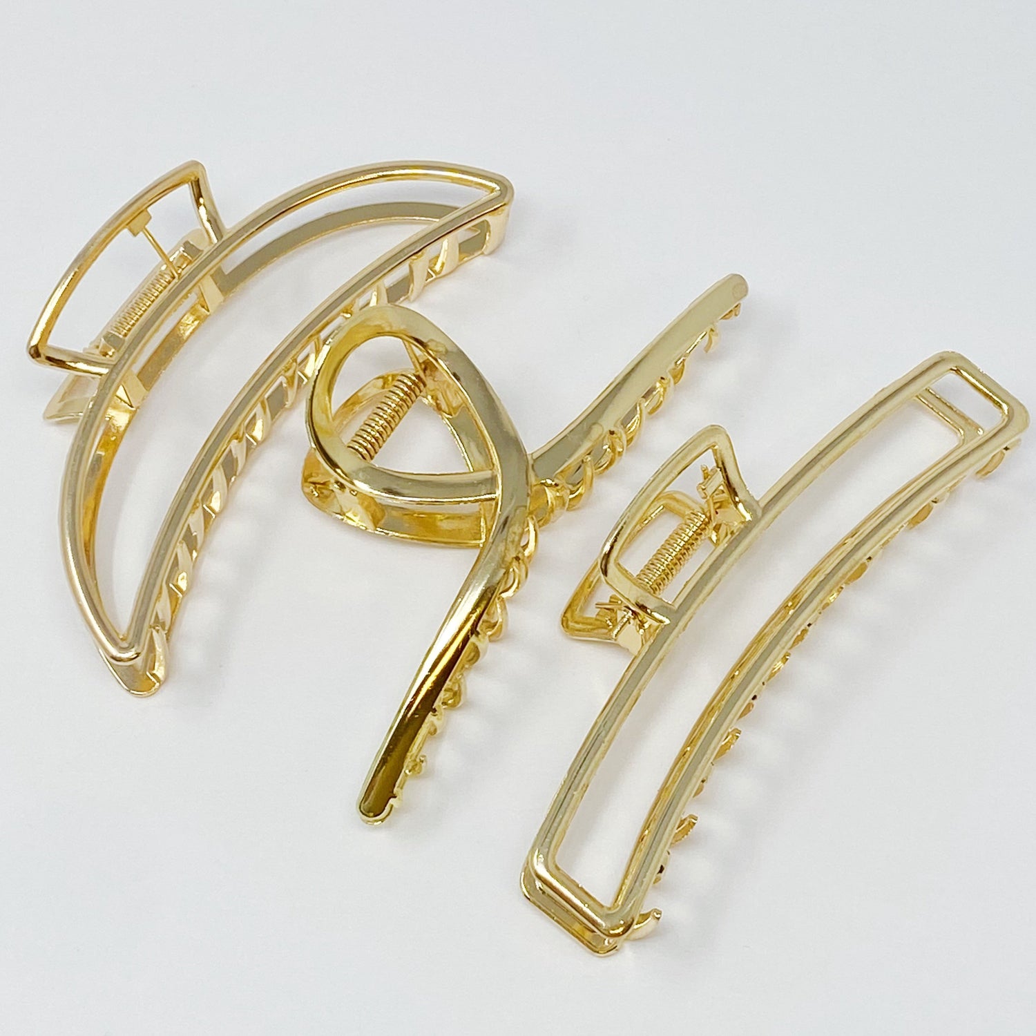 Set of three gold hair claw clips from Fuchsia Hercules, jewelry accessories for securing hair styles.