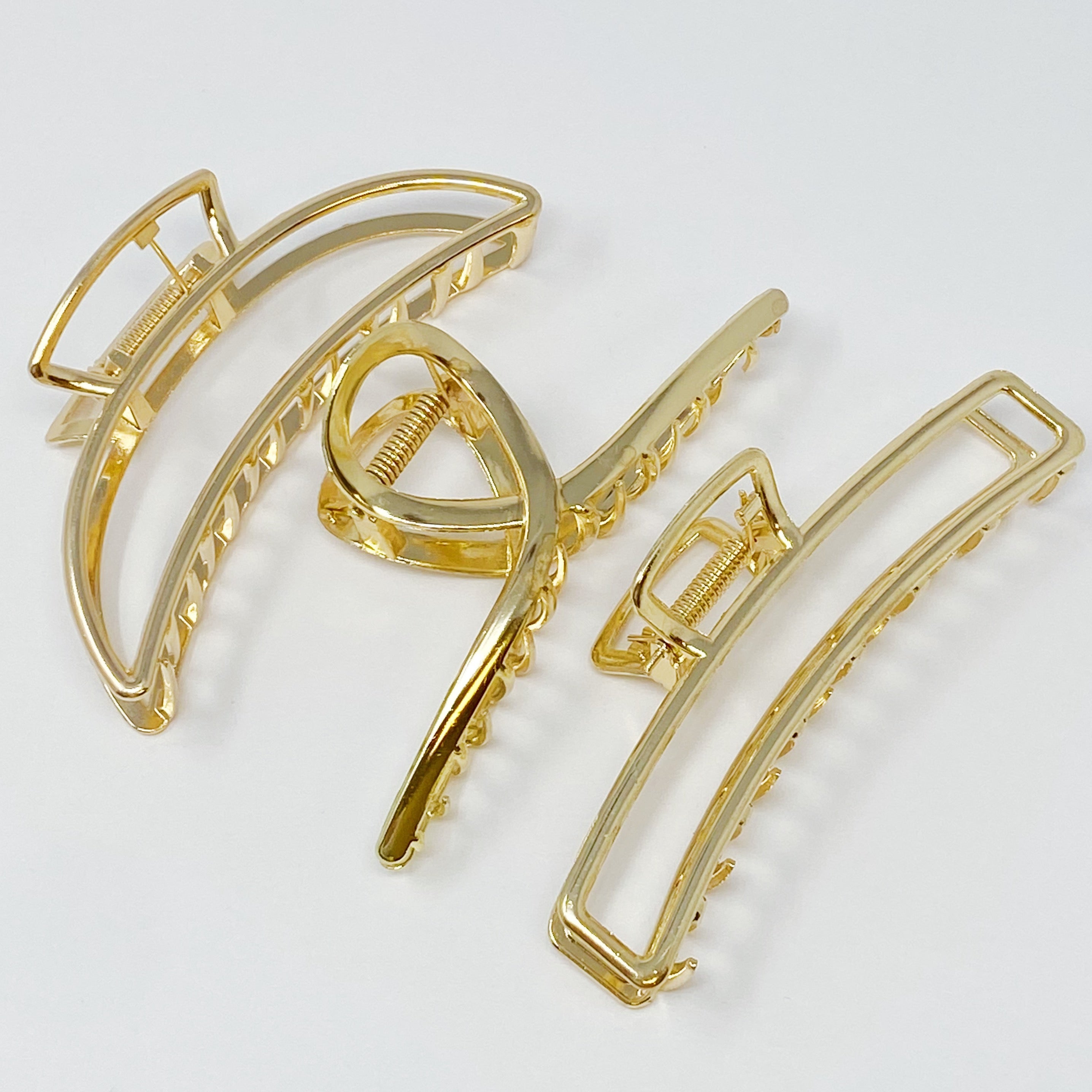 Set of three gold hair claw clips from Fuchsia Hercules, jewelry accessories for securing hair styles.