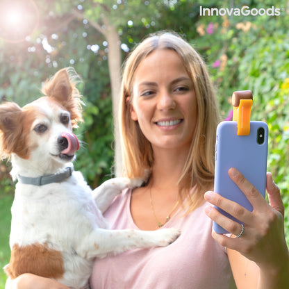 Pet selfie clip from Pefie InnovaGoods, attached to a smartphone, with a pet in the background for better pet photos.