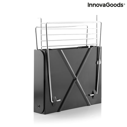 Bigbuy Foldecue InnovaGoods mini folding portable charcoal barbecue in a garden setting, showing its compact design and cooking surface.