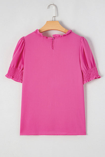 Pink rose solid color smocked puff sleeve blouse by Carmine Juneberry, featuring a feminine design with puffed sleeves and a fitted bodice.