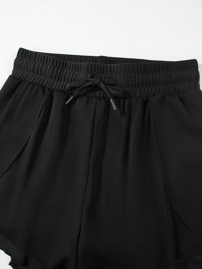 Pear Daisy high waisted drawstring swim shorts with a relaxed fit, displayed on a hanger with a light background.