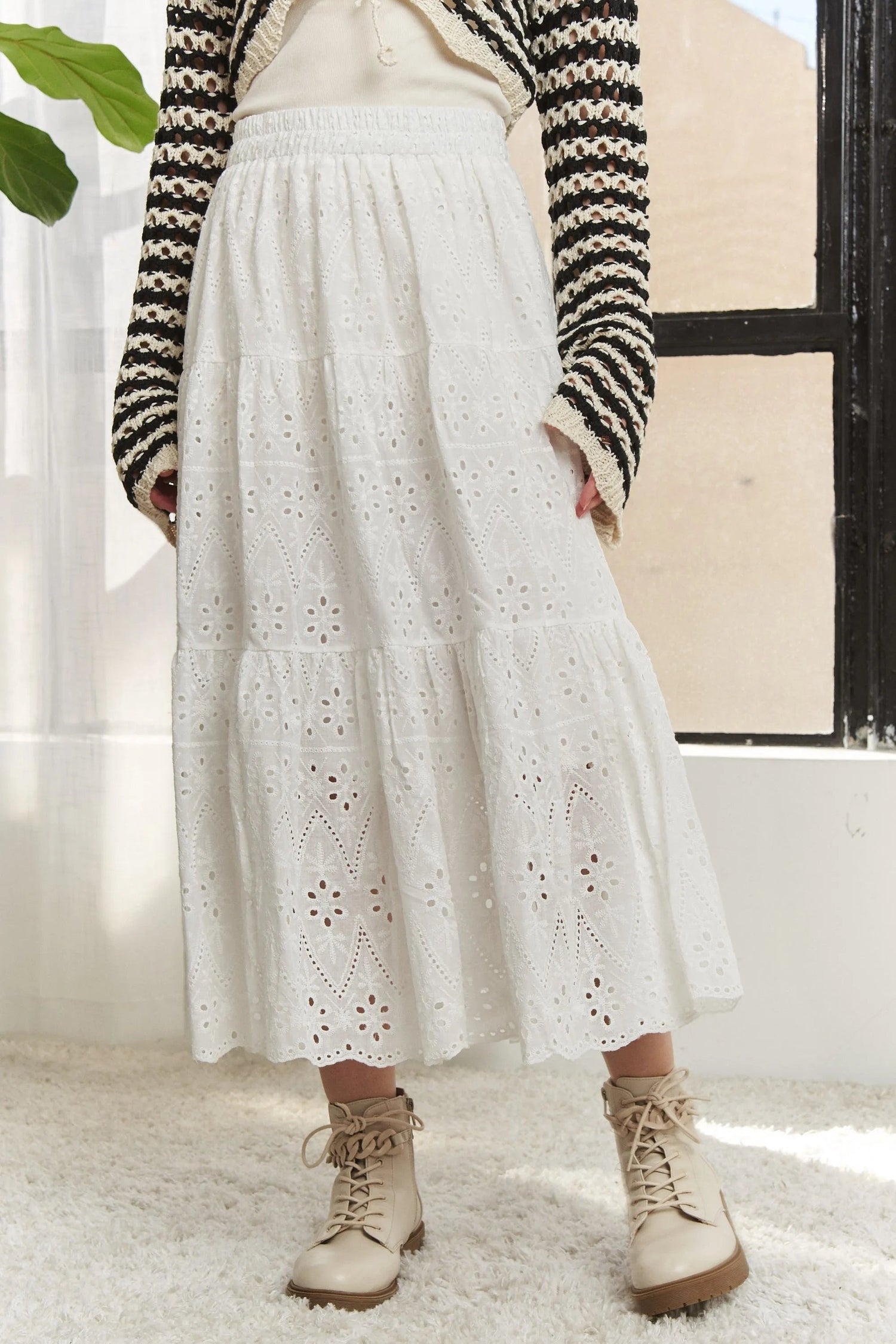 Jade Icarus ADORA elastic waistband tiered midi skirt with flowing fabric and layered design, displayed on a hanger.