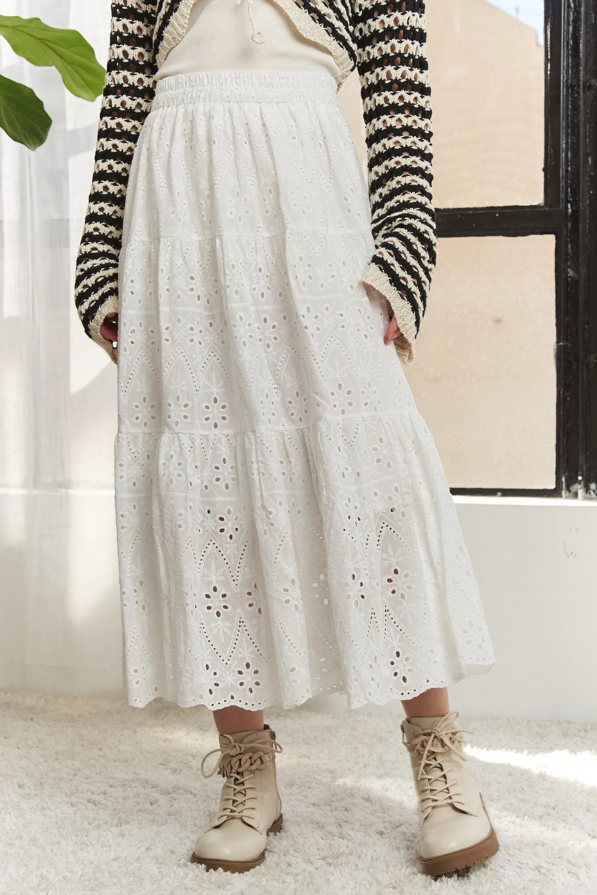 Jade Icarus ADORA elastic waistband tiered midi skirt with flowing fabric and layered design, displayed on a hanger.