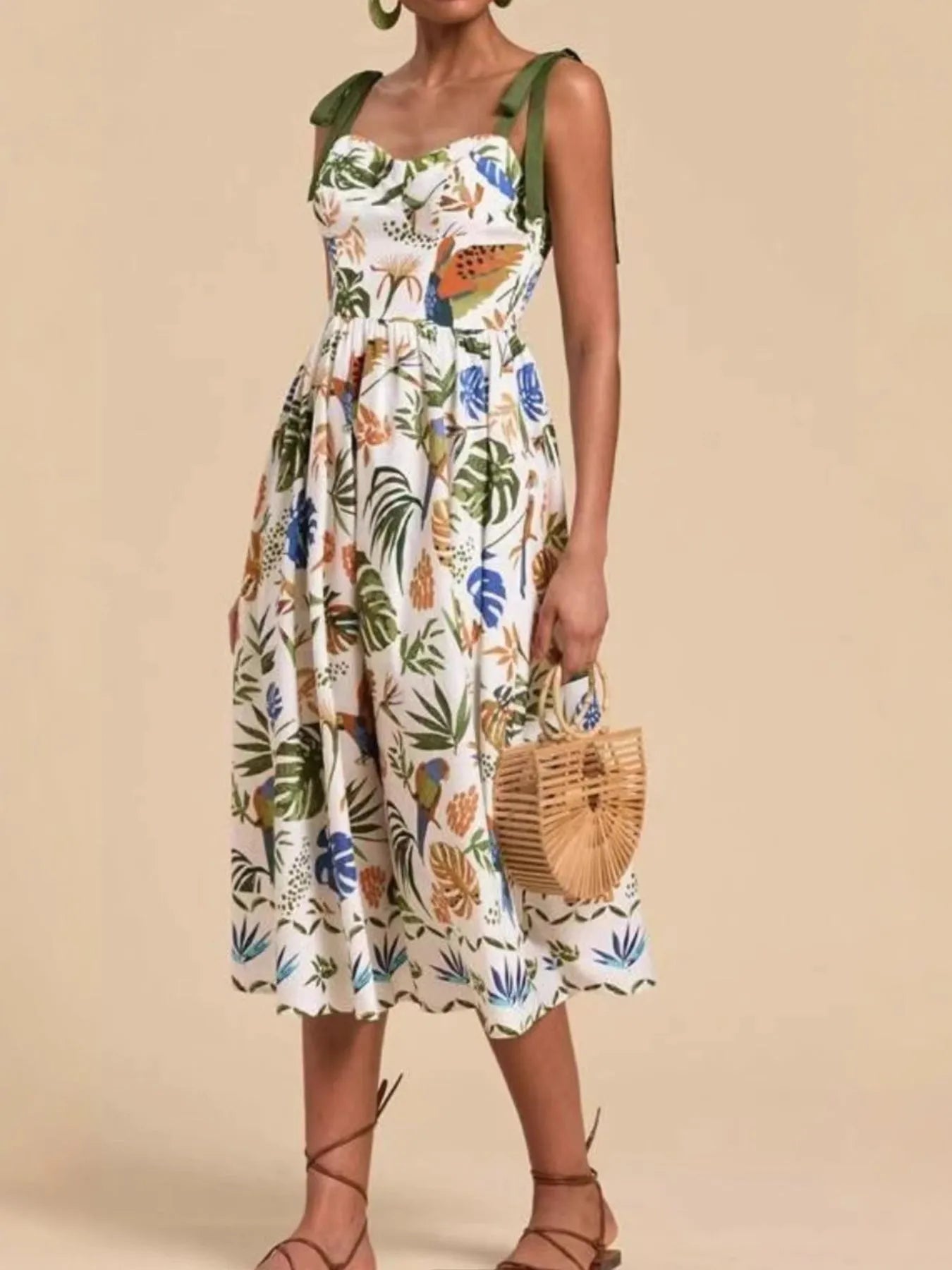 Tropical print tie-shoulder sweetheart neck midi dress by Carmine Juneberry, featuring vibrant floral patterns and a flowing silhouette.