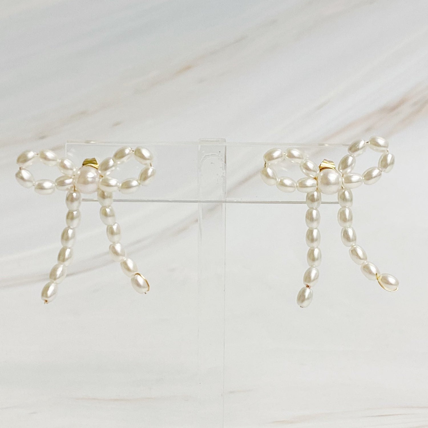 Fuchsia Hercules pearl bow ballerina earrings with delicate white pearls and gold-tone bow design, jewelry and watch accessory