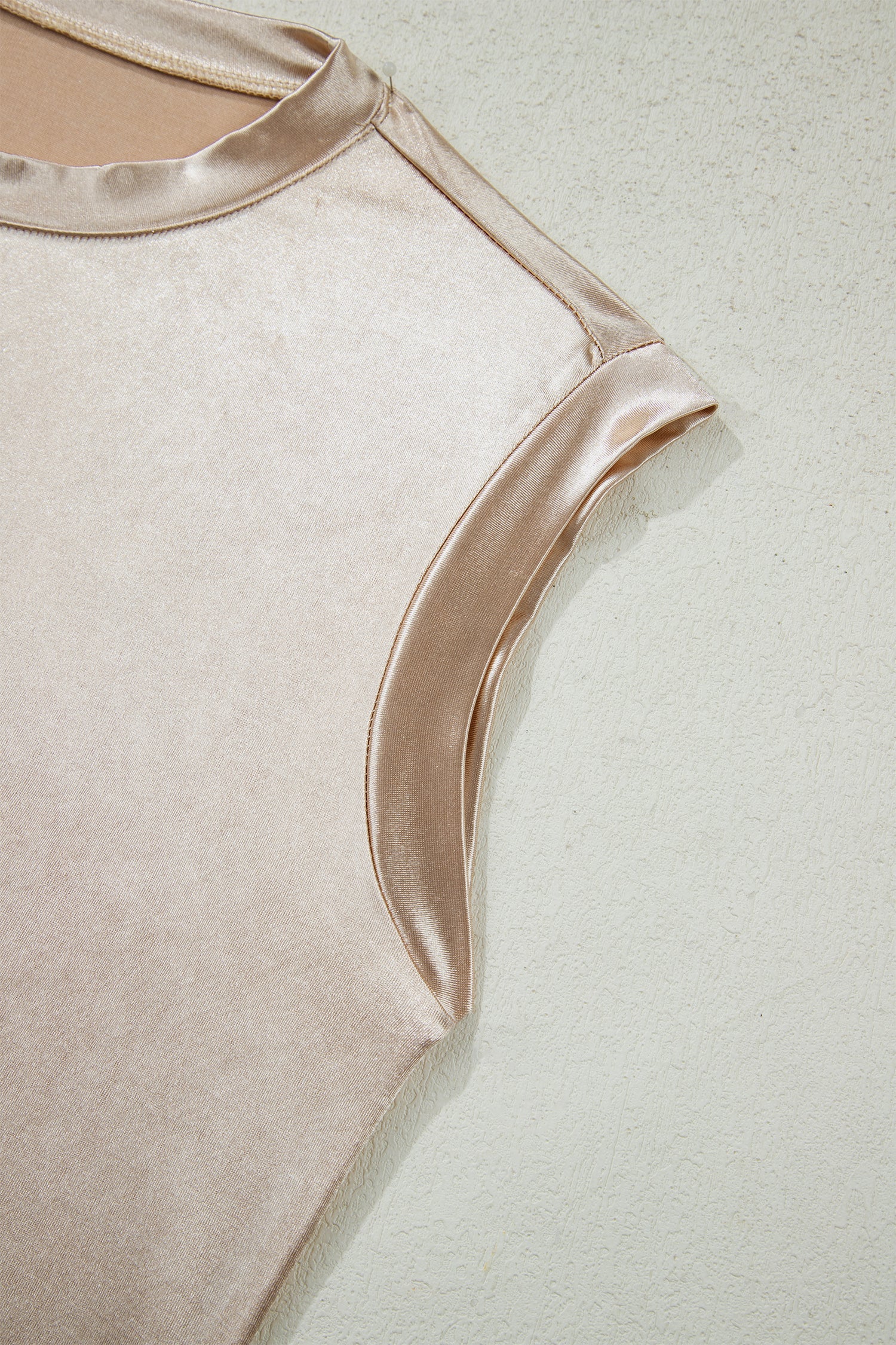 Metallic round neck tank top from Byzantium Bay displayed on a hanger, showcasing shiny fabric and sleeveless design.