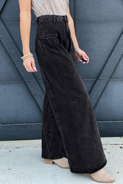 Dark grey pleated wide-leg denim pants by Carmine Juneberry with mineral wash finish, shown on a model.