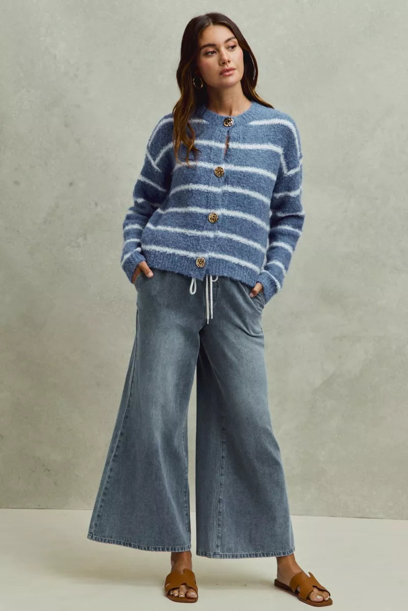 Pear Daisy SO ME mid-rise elastic waist flare denim jeans for women, shown on a model with a casual home setting background.