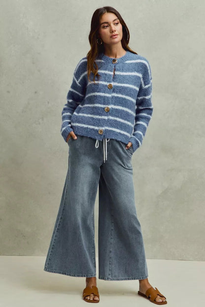Pear Daisy SO ME mid-rise elastic waist flare denim jeans for women, shown on a model with a casual home setting background.