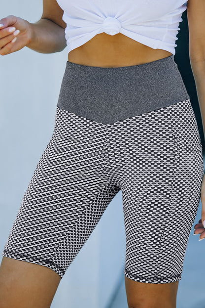 Black ruched yoga shorts with side pockets and butt lifting design by Harlequin Daisy, ideal for active or casual wear.