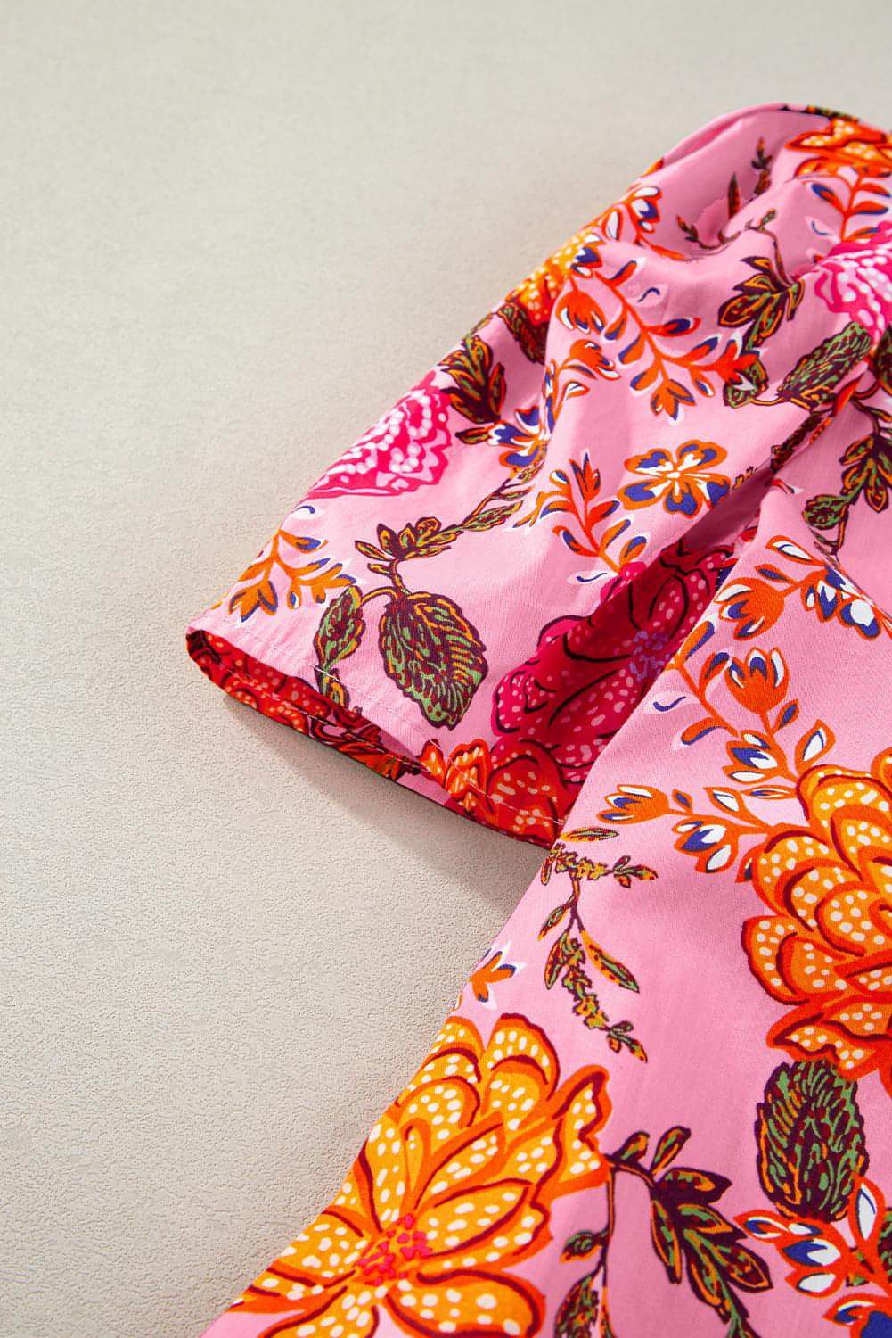 Pink floral bubble sleeve V-neck ruffled mini dress by Carmine Juneberry, featuring a stylish floral pattern and playful ruffle details.