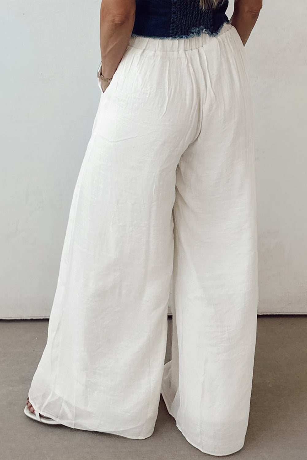 Women’s solid drop waist pleated wide-leg pants by Byzantium Bay, shown in a relaxed fit with a high waist and flowing fabric.