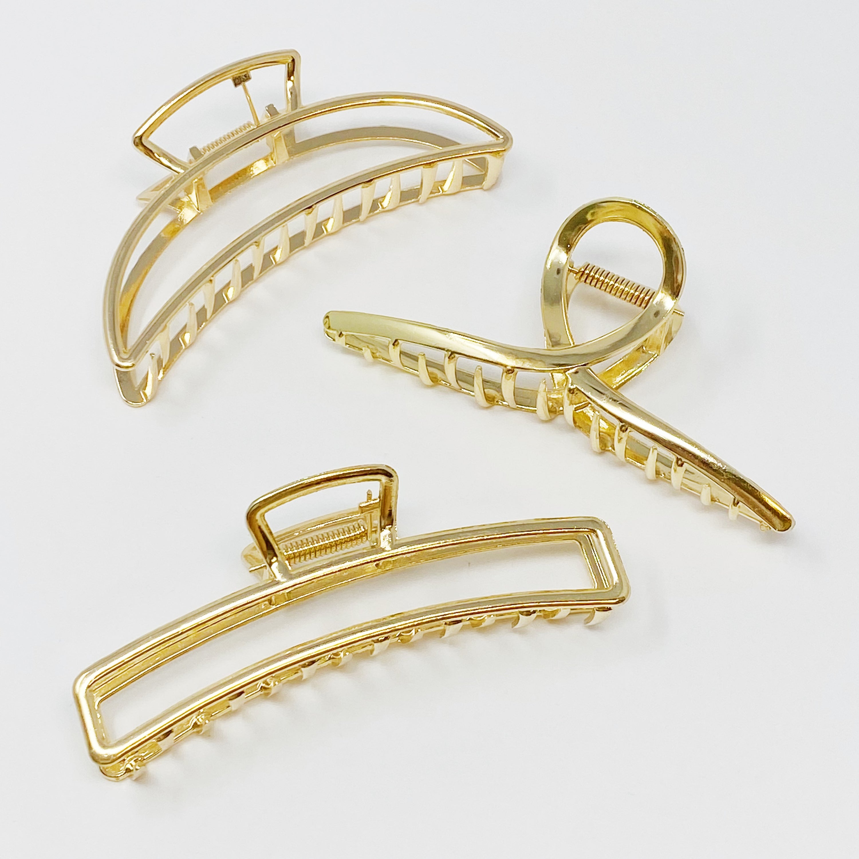 Set of three gold hair claw clips by Fuchsia Hercules, stylish jewelry accessories for securing hair.