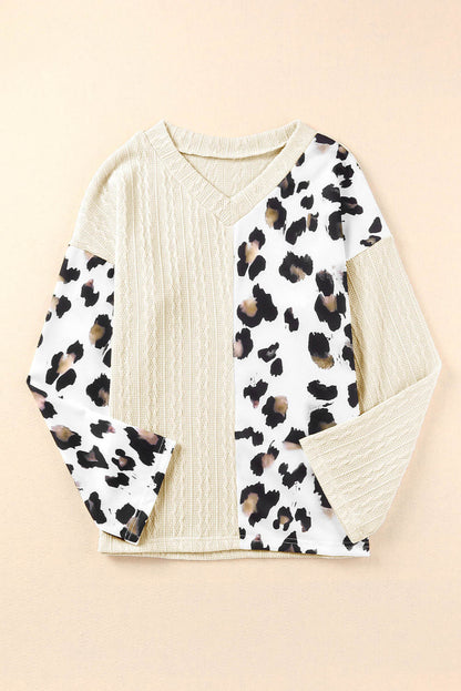 Beige asymmetric leopard patchwork wide sleeve V-neck sweater by Carmine Juneberry, featuring bold animal print and relaxed fit.