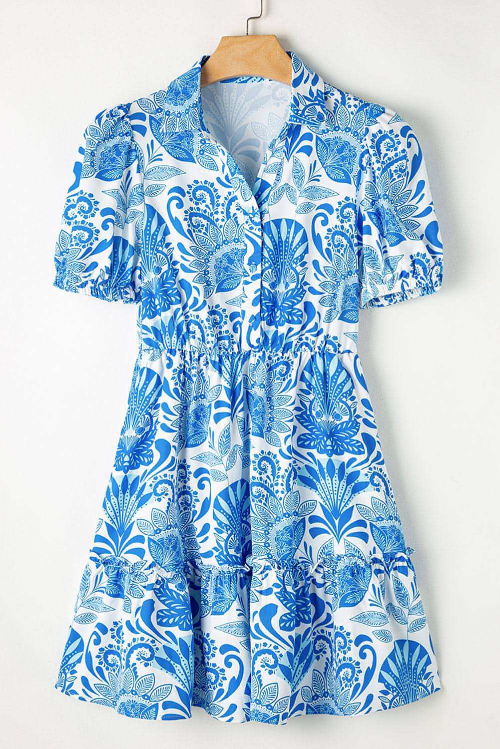 Sky blue retro floral print mini dress with ruffled hem and drawstring waist by Carmine Juneberry, perfect for summer.