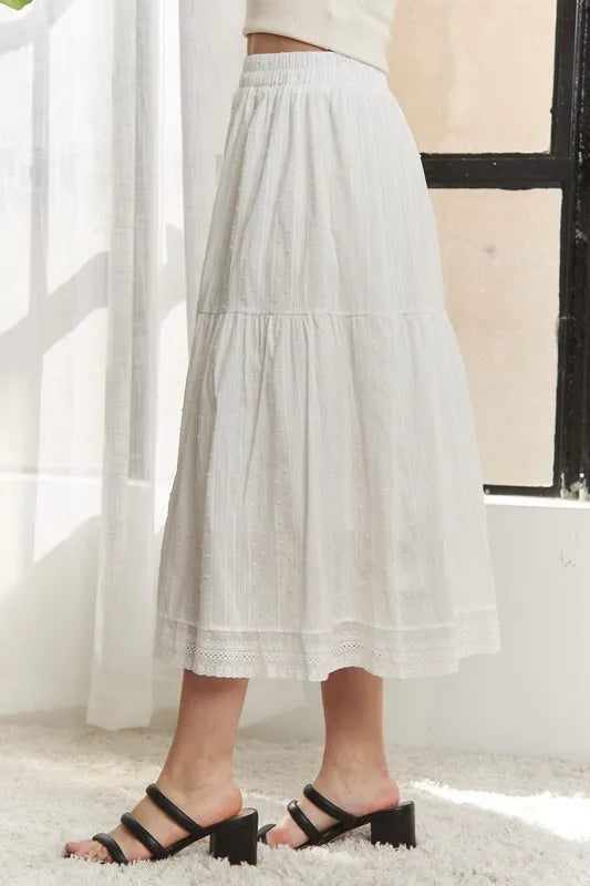 Jade Icarus ADORA elastic waistband tiered midi skirt with flowing fabric, displayed in a stylish fashion setting.