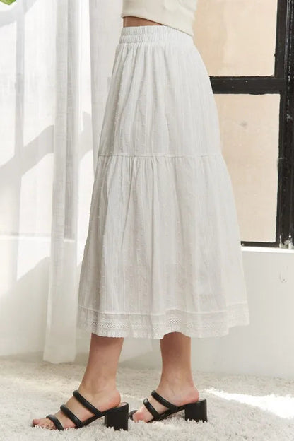 Jade Icarus ADORA elastic waistband tiered midi skirt with flowing fabric, displayed in a stylish fashion setting.