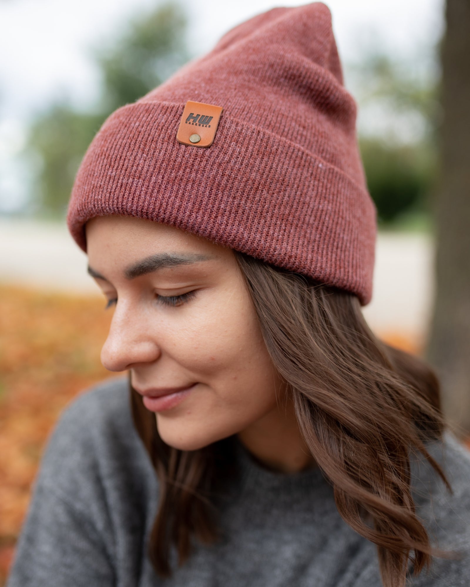 Azure Arrowwood HAAKWEAR knit cuffed beanie in rusty burgundy, featuring a cozy, textured knit pattern and a snug fit.
