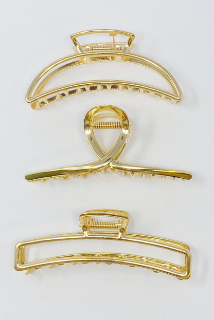 Set of three gold hair claw clips from Fuchsia Hercules, stylish jewelry accessories for securing hair.