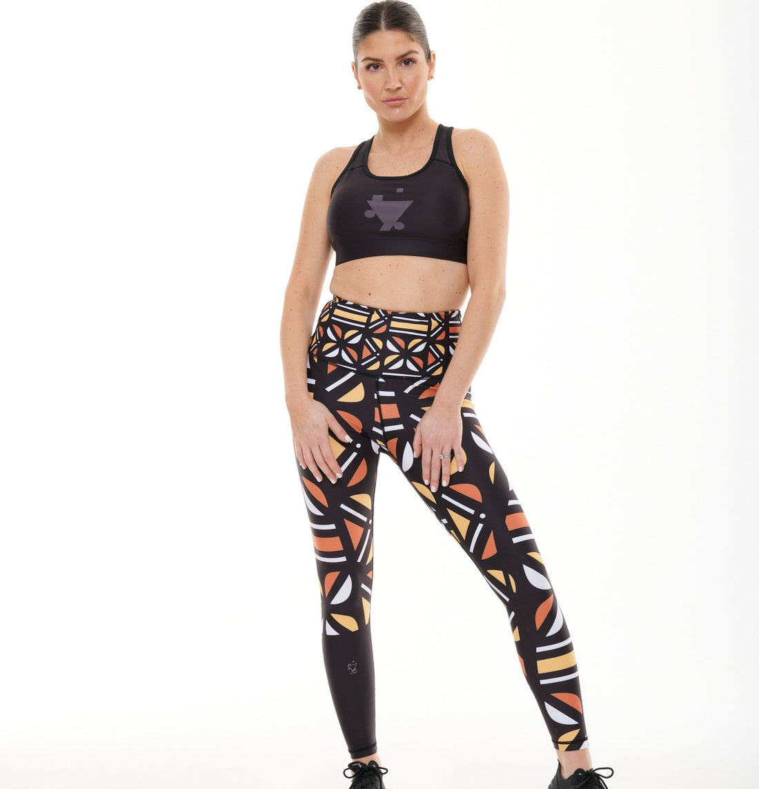 White Oliver Batiq Vibrant Activewear Leggings with colorful geometric patterns, close-up view of the stretchy fabric.
