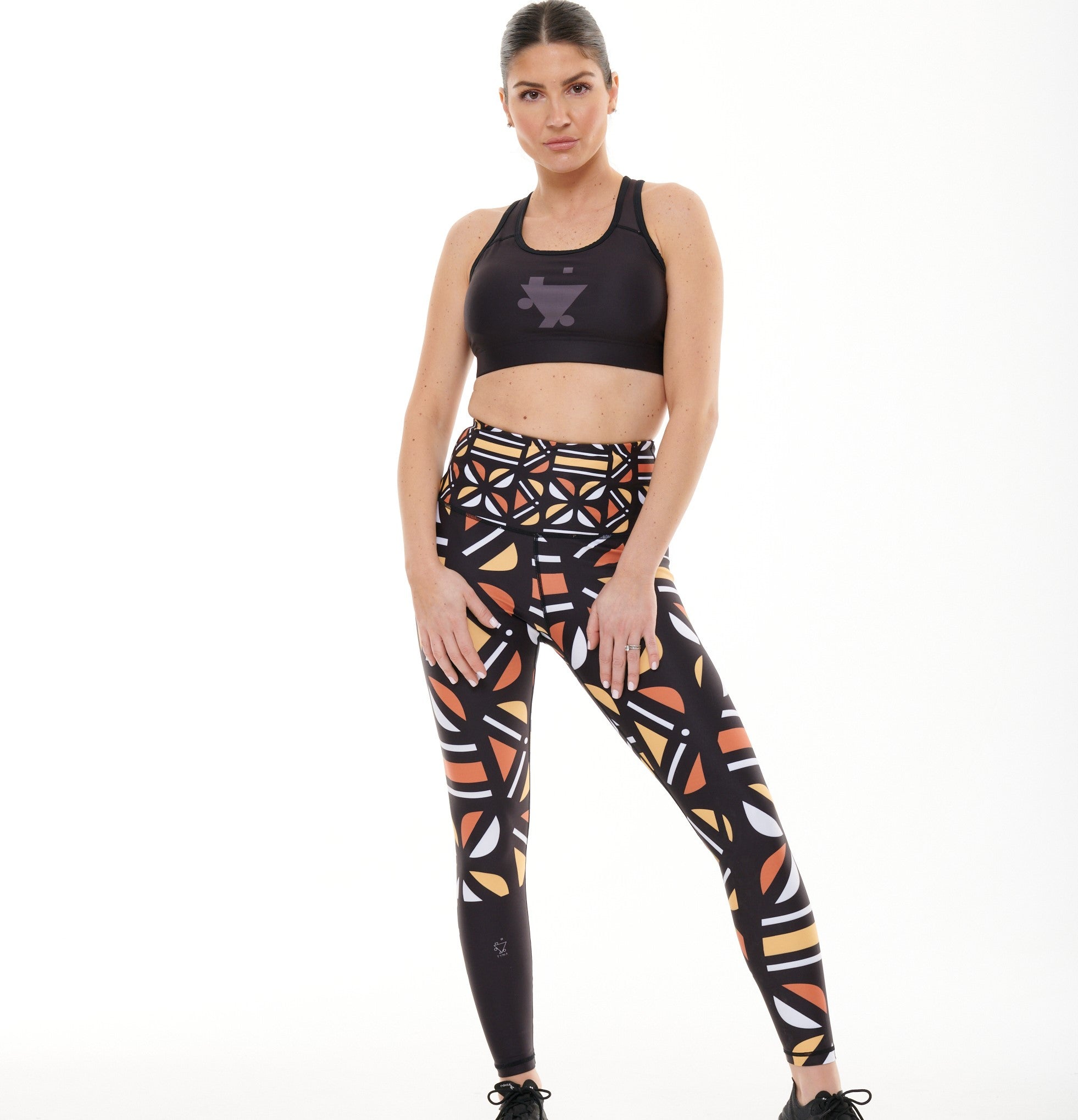 White Oliver Batiq Vibrant Activewear Leggings with colorful geometric patterns, close-up view of the stretchy fabric.