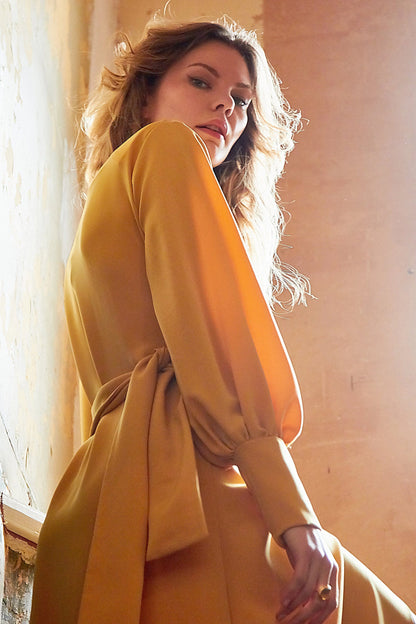 Amber V-neck wrap maxi dress with side slit by Blush Athena, featuring a stylish mustard-colored dress with flowing fabric.