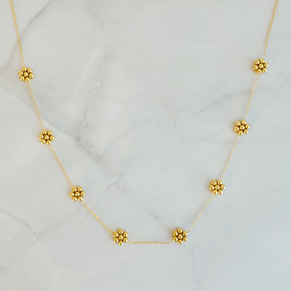 Dainty golden bead flower necklace by Fuchsia Hercules featuring waterproof stainless steel jewelry with delicate floral design.