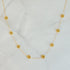 Dainty golden bead flower necklace by Fuchsia Hercules featuring waterproof stainless steel jewelry with delicate floral design.