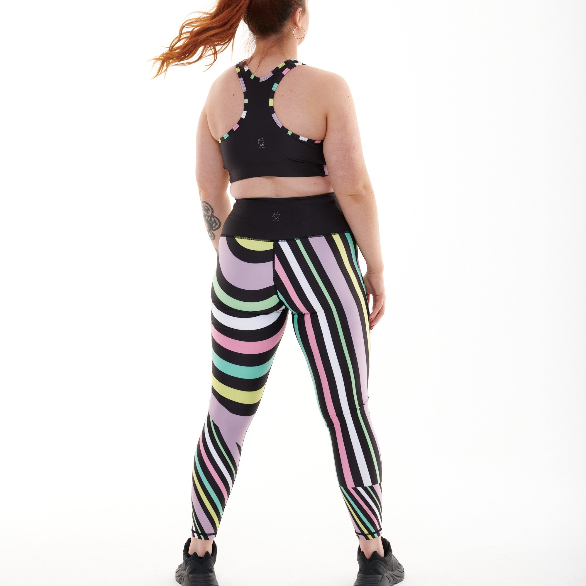 White Oliver Aso-Oke pastel vibrant activewear leggings shown from the back with colorful traditional African fabric design.