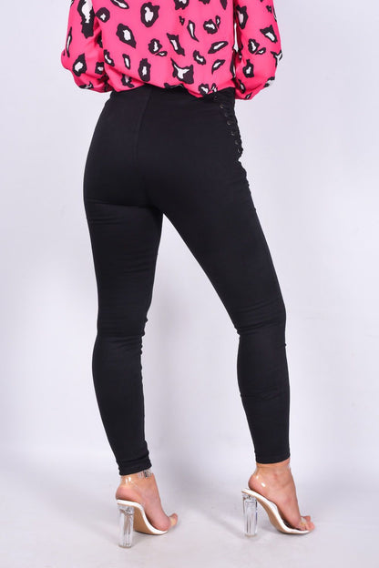 Black denim skinny jeans with lace-up details and a zip front, designed for women by Azure Theseus.