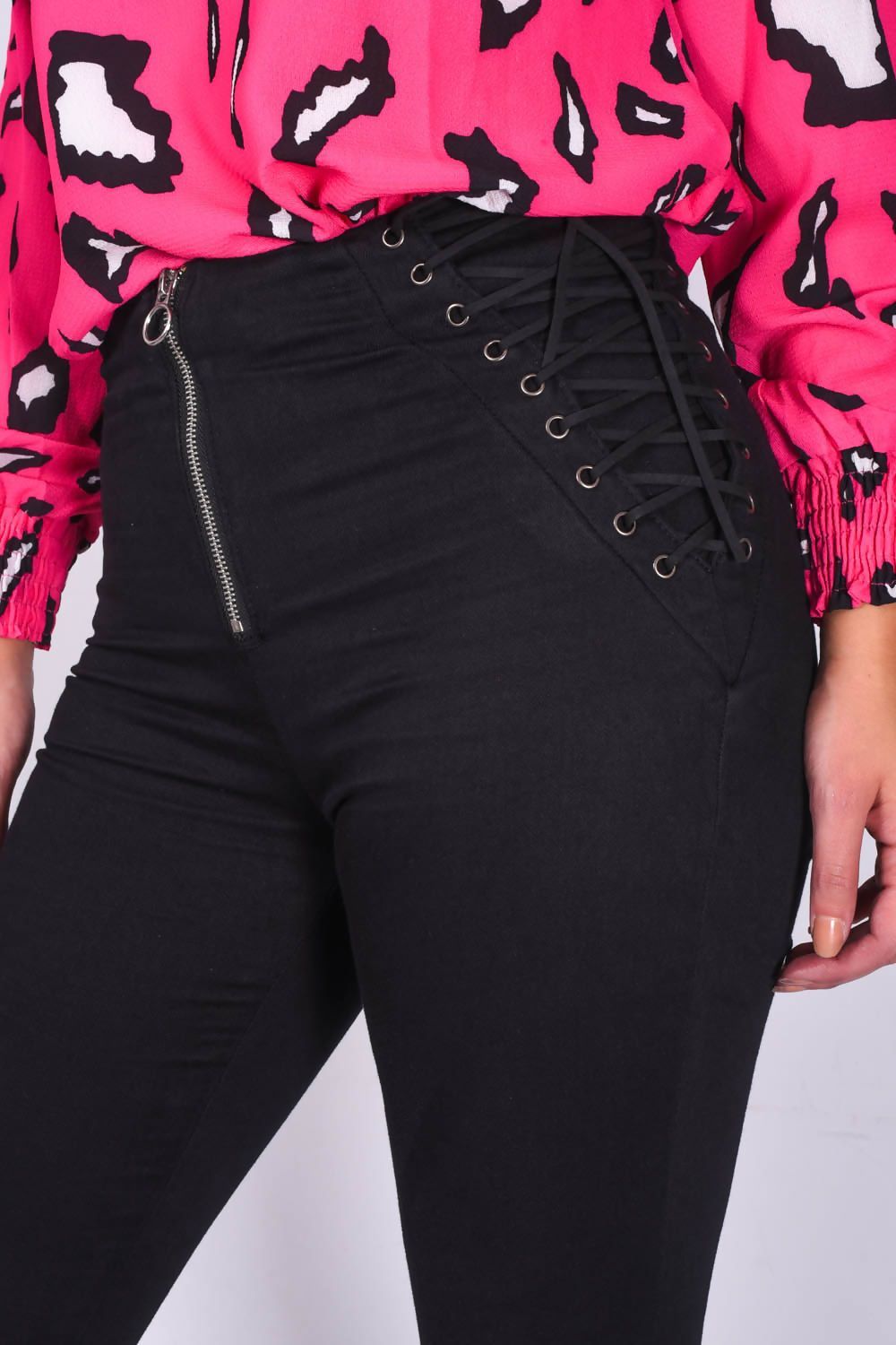 Black denim skinny jeans with lace-up detail and zip front for women by Azure Theseus, shown on a model.