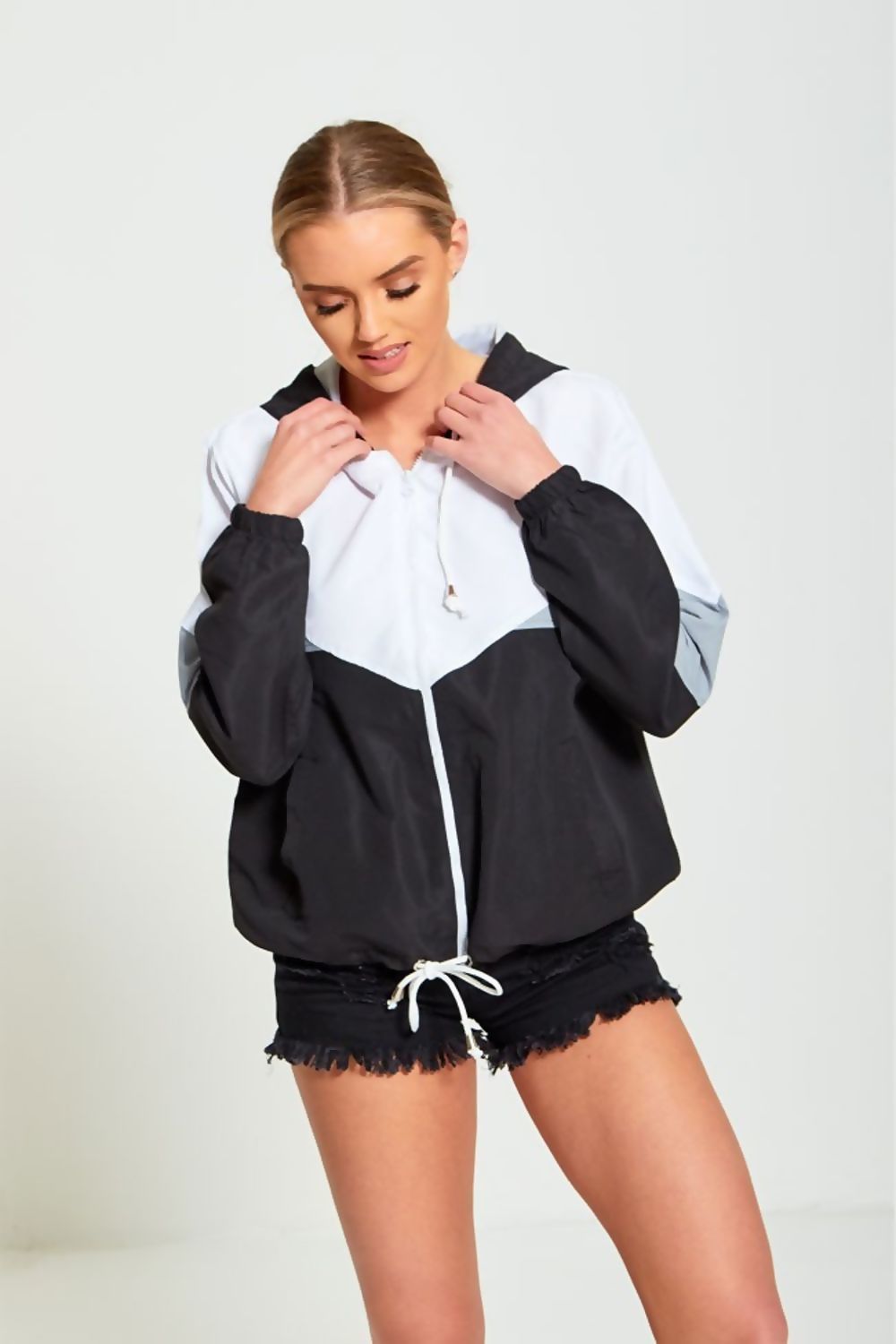 Black two-tone cagoule jacket for women by Azure Theseus, lightweight waterproof outerwear with adjustable hood and zip closure.