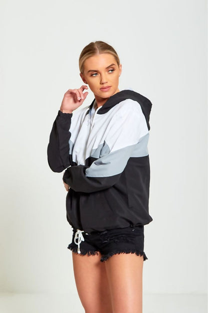 Black two-tone cagoule jacket for women by Azure Theseus, lightweight weather-resistant outerwear with hood and stylish design.