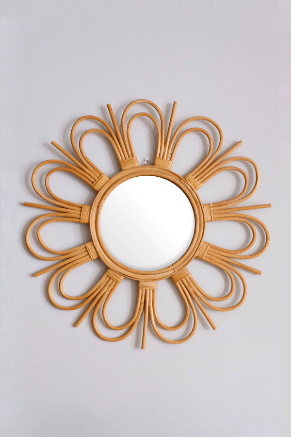 Sunburst natural rattan mirror with a floral design, featuring a round shape and intricate woven rattan frame for home decor.