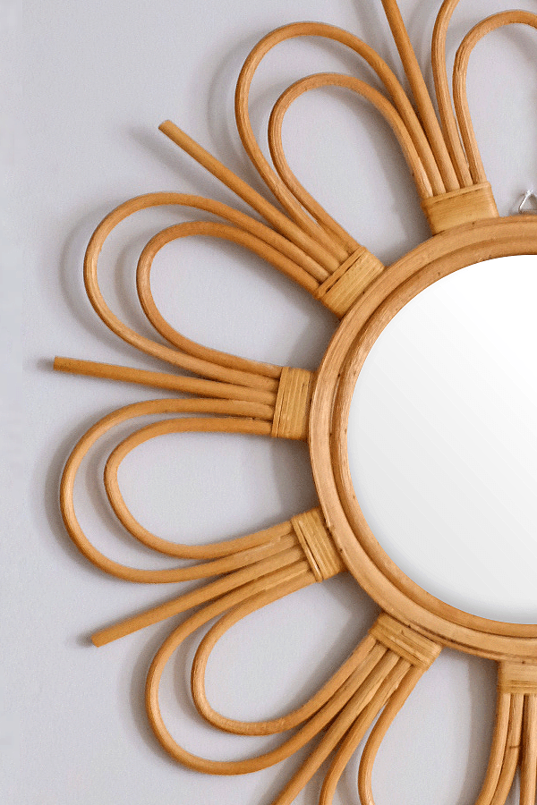 Sunburst natural rattan mirror with floral design, home decor by DC-Hathorway, showcasing intricate rattan weaving and floral accents.