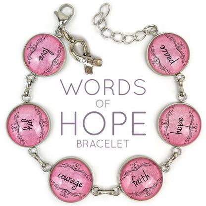 Pink bracelet with glass charm featuring words of hope like love, joy, courage, faith, hope, and peace by Orchid Briseis.