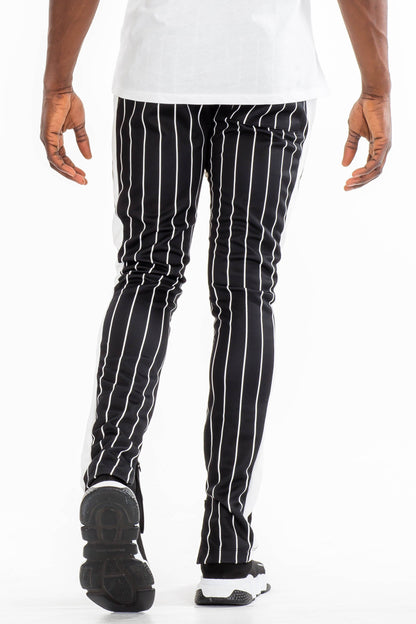 Lime Milo pinstripe track pants with a relaxed fit and elastic waistband, featuring vertical white pinstripes on navy fabric.